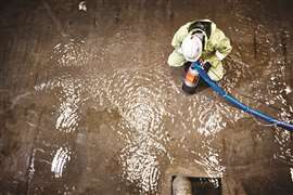 Aeriel show of a worker using a pump on flood water