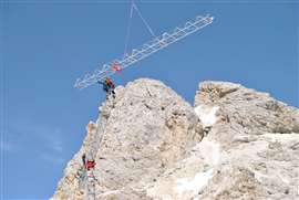 Engineering teams lowering the crane's component parts into position