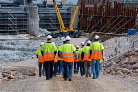 Construction workers walking (Image: Adobe Stock)