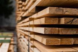 Piles of wooden boards in the sawmill, planking. Warehouse for sawing boards on a sawmill outdoors. Wood timber stack of wooden blanks construction material.